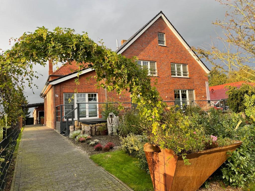 een bakstenen huis met een tuin ervoor bij Freimuth`s Hof in Südbrookmerland