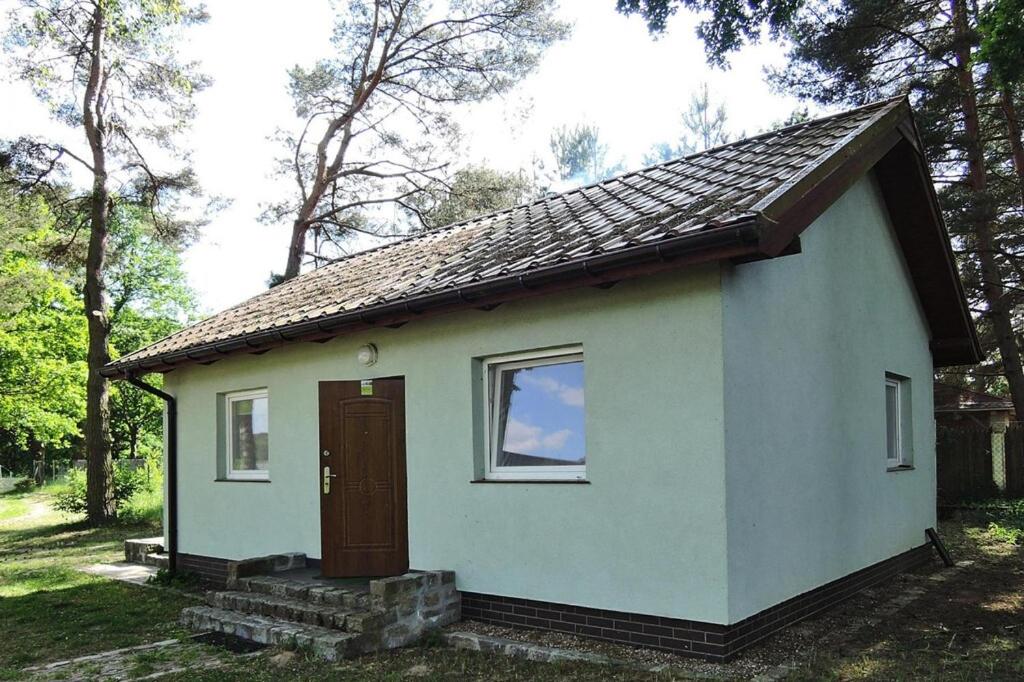 ein kleines Haus mit einem Fenster und einer Tür in der Unterkunft Holiday House in Szczecin at the lake with the terrace in Stettin