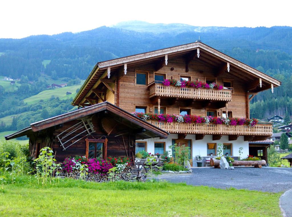 uma casa de madeira com flores na varanda em Ferienwohnung Lerchenhof em Wald im Pinzgau