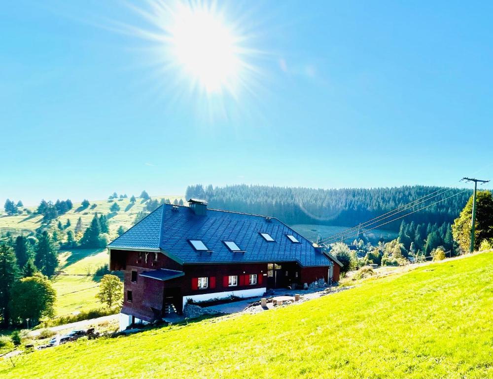 a barn on a hill with the sun in the sky at RotmeerHaus in Feldberg