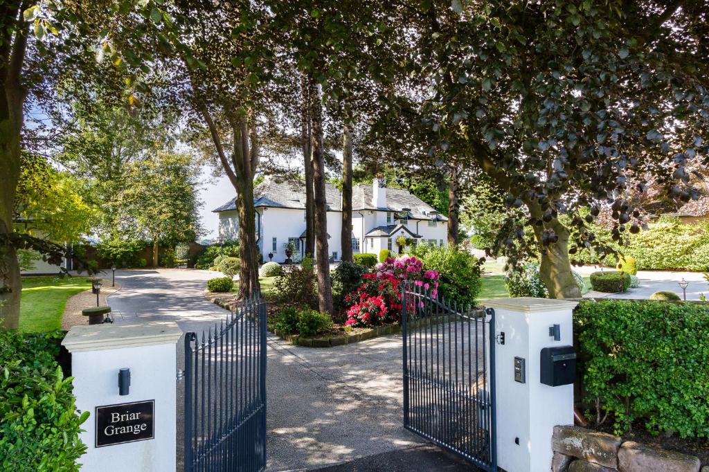 a gate in front of a house with flowers at Self contained accommodation near Delamere forest in Oakmere