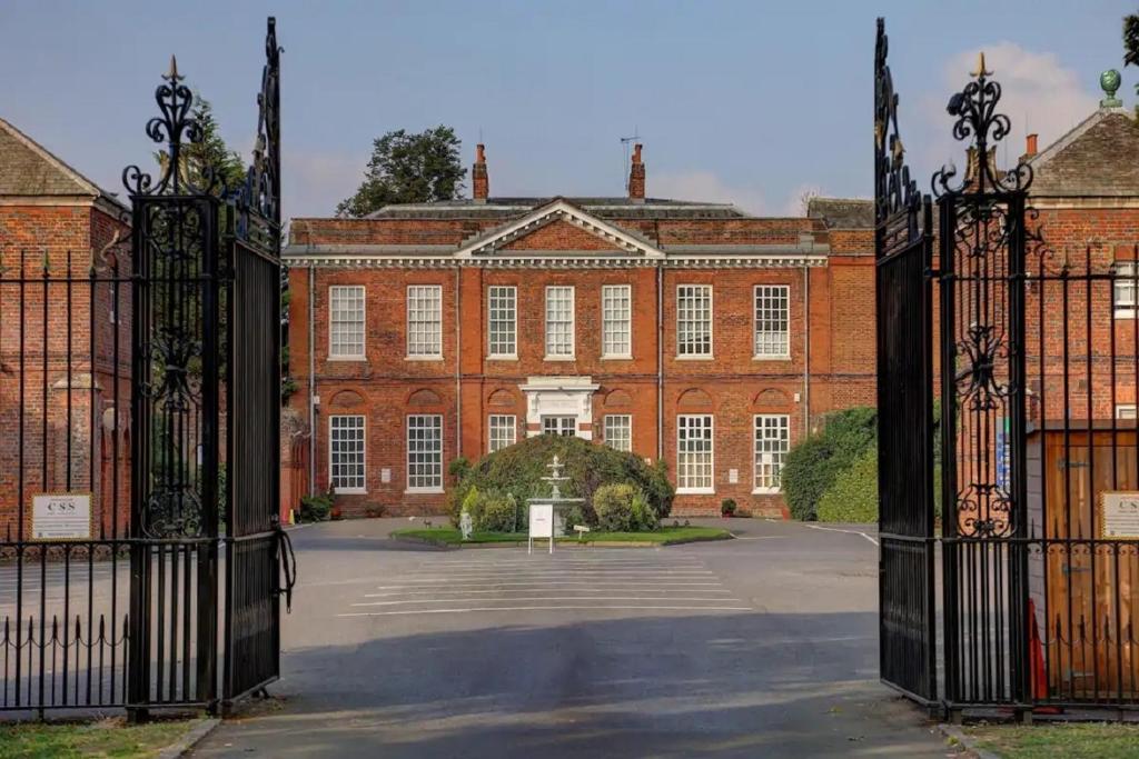 una puerta abierta a un gran edificio de ladrillo rojo en SK Baylis House Hotel, en Slough