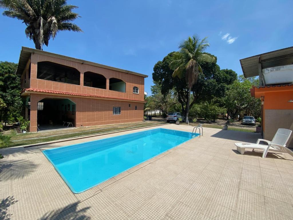 a swimming pool in front of a house at CASA inteira entre Guaratiba e Campo Grande, Rio de Janeiro, RJ - a 40 min da praia, próximo ao Estádio Miecimo da Silva e Park Shopping-Ideal para descanso, encontros, festa e lazer-3000 m2 in Rio de Janeiro