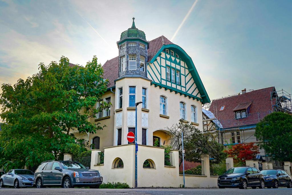 a large building with cars parked in front of it at Traumhaft wohnen in Jugendstilvilla in Speyer