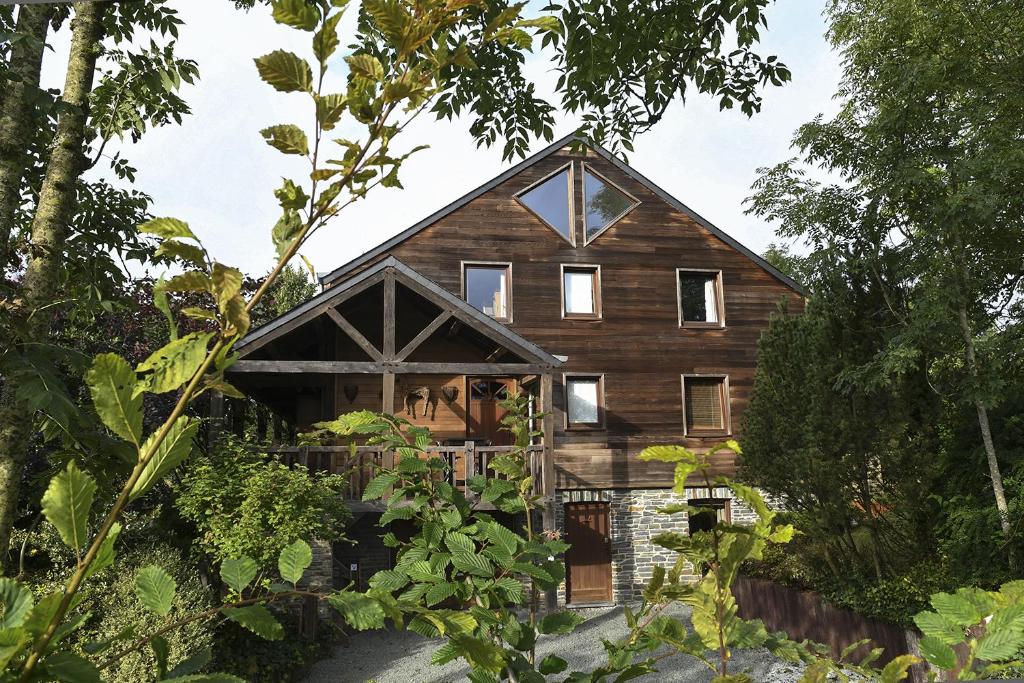 - une vue sur l'extérieur d'une maison en bois avec des arbres dans l'établissement Saint-Hubert d'Ardenne, à Hatrival