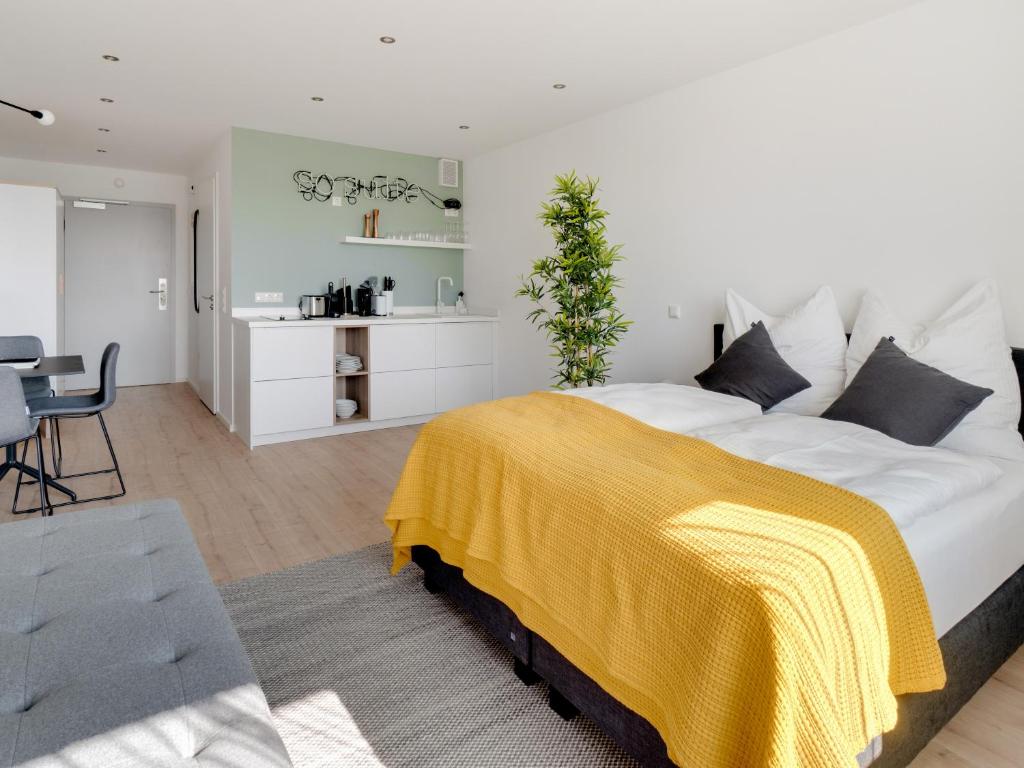 una camera da letto con un grande letto con una coperta gialla di limehome Darmstadt Wilhelminenstraße - Digital Access a Darmstadt