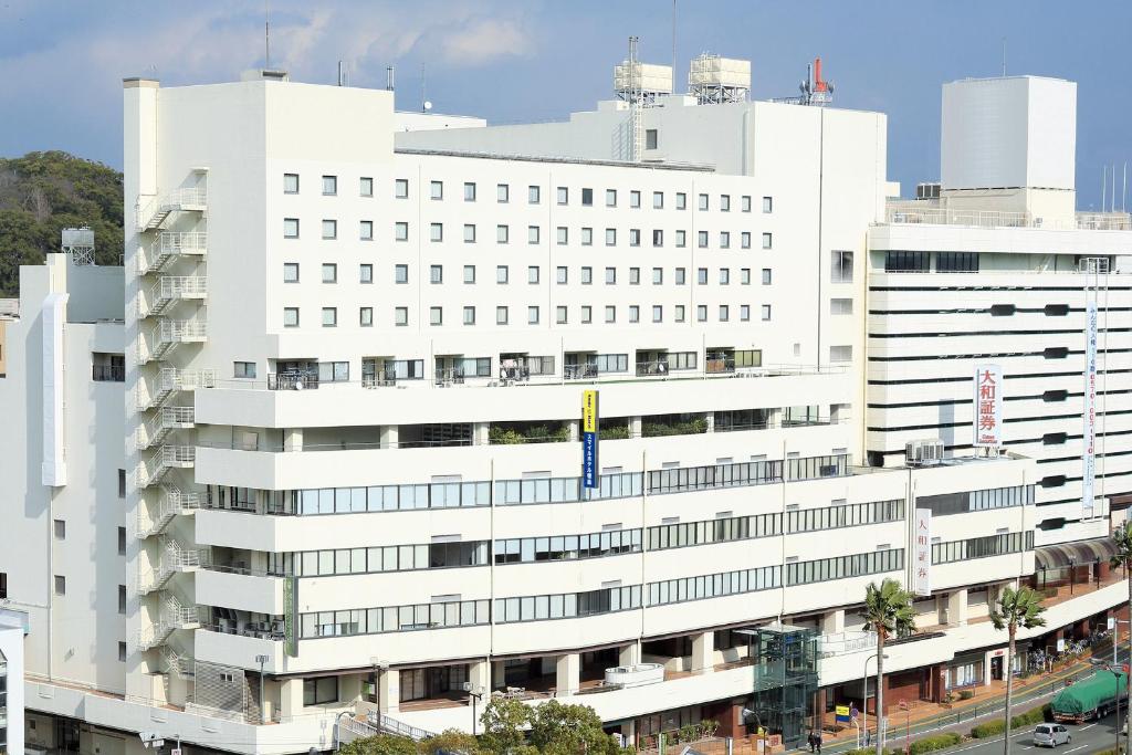 ein großes weißes Gebäude mit vielen Fenstern in der Unterkunft Smile Hotel Tokushima in Tokushima