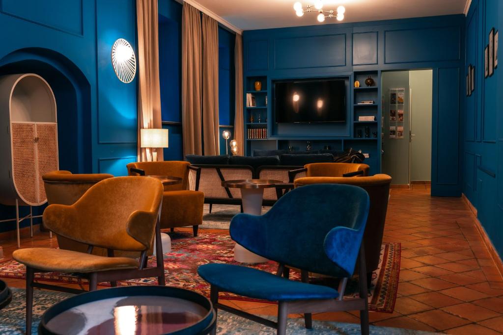 d'un salon avec des murs bleus, des chaises et une télévision. dans l'établissement Hotel Erbenhof, à Weimar