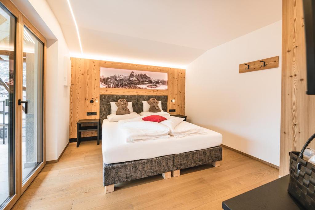 um quarto com uma grande cama branca num quarto em Residence Altea em Ortisei