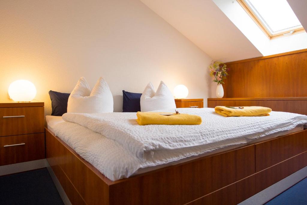 a bedroom with a bed with two yellow towels on it at Pension Freiraum Guesthouse Berlin in Berlin