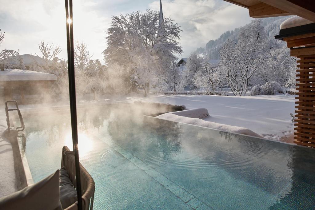 wanna z hydromasażem ze śniegiem na ziemi w obiekcie MalisGarten Green Spa Hotel w mieście Zell am Ziller