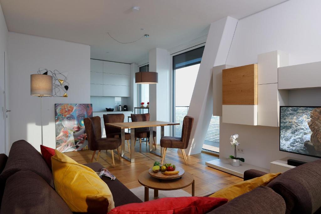 uma sala de estar com um sofá e uma mesa em Triiiple Suites Level 21 mit Balkon und Tiefgarage em Viena