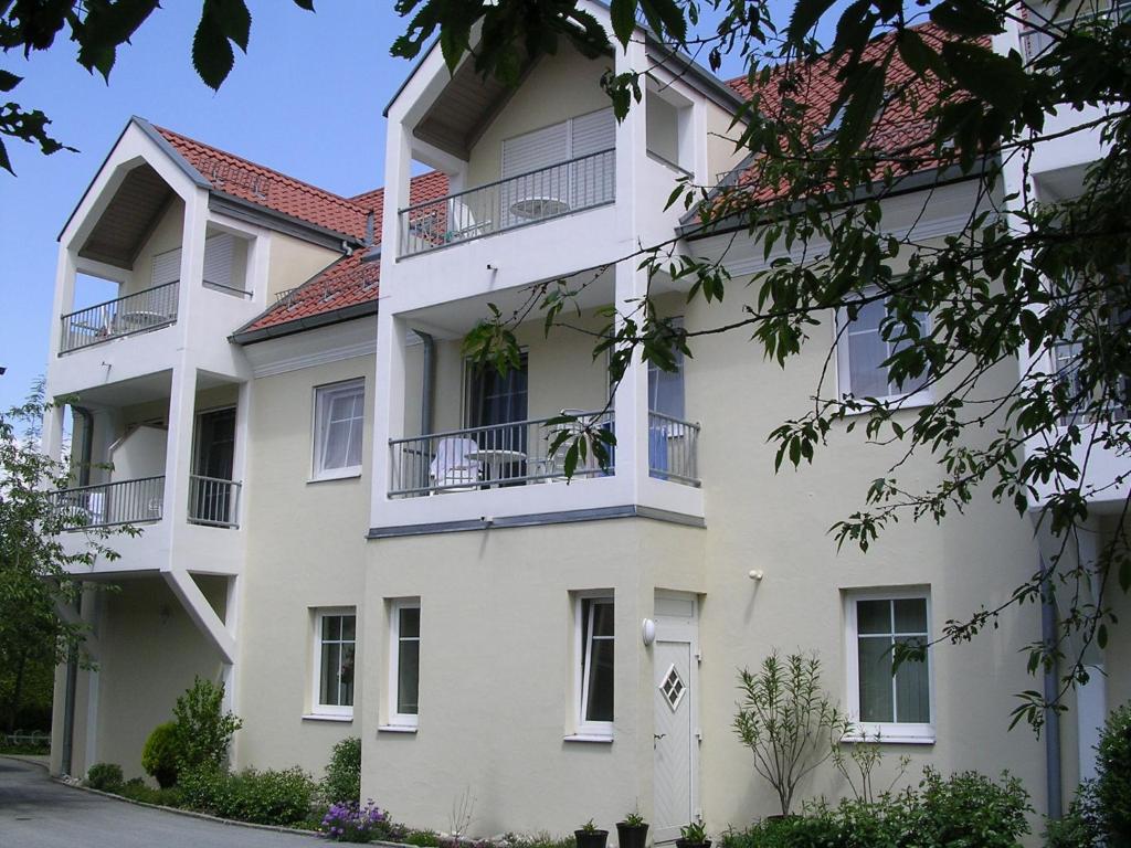 een wit gebouw met een rood dak bij Appartementhaus Zum Fuchswirt in Bad Füssing