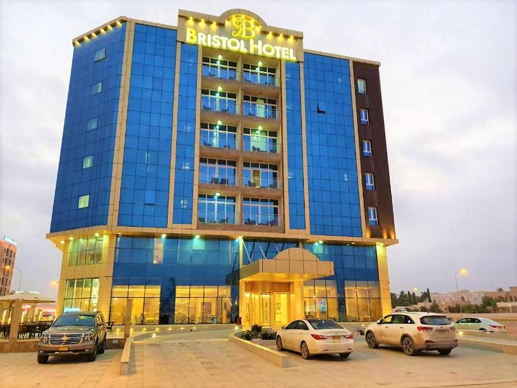 un edificio con coches estacionados en un estacionamiento en Bristol Hotel Salalah, en Salalah