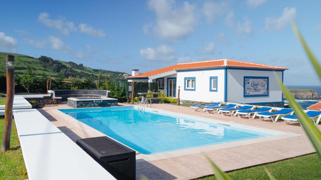 - une piscine avec des chaises et une maison dans l'établissement Quinta Rico - House II, à Praia da Vitória