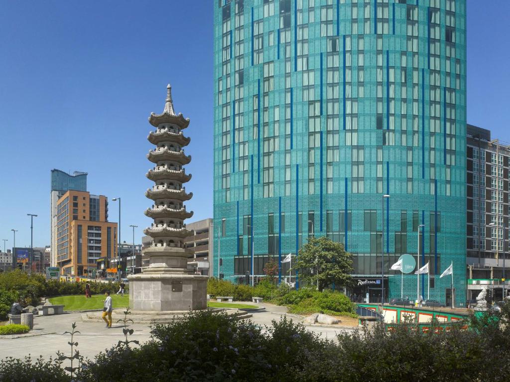 una estatua frente a un edificio con un edificio alto en Radisson Blu Hotel, Birmingham en Birmingham