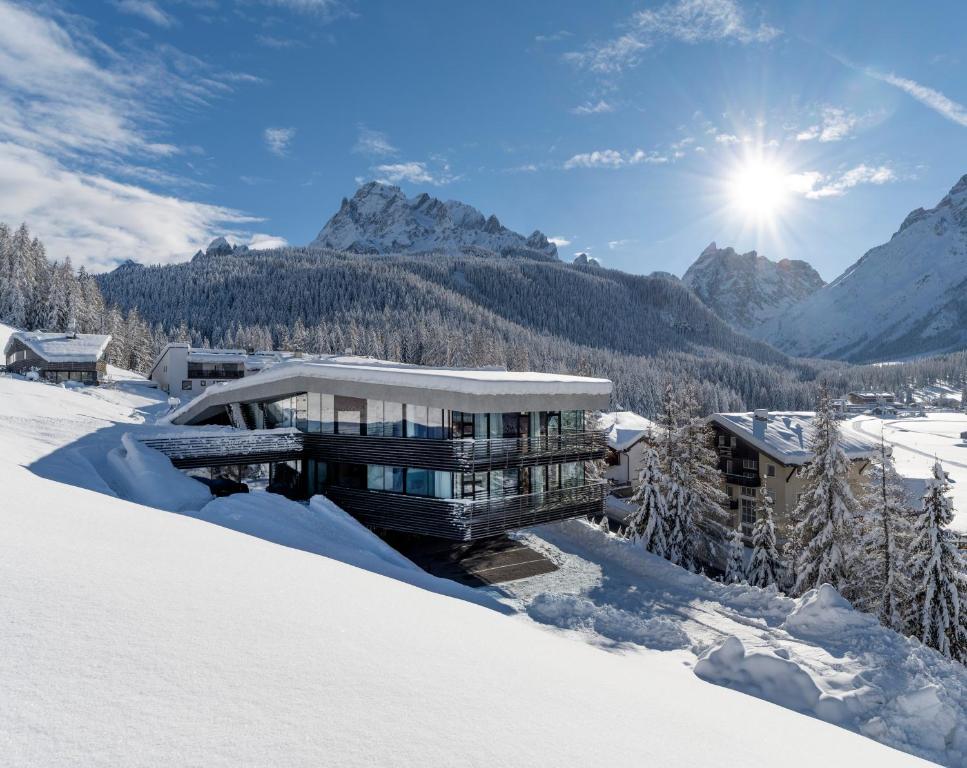 een huis in de sneeuw in de bergen bij Paramount Alma Suites in Sesto