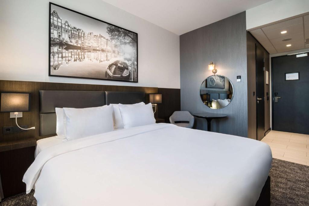 uma grande cama branca num quarto de hotel em Radisson Hotel & Suites Amsterdam South em Amstelveen