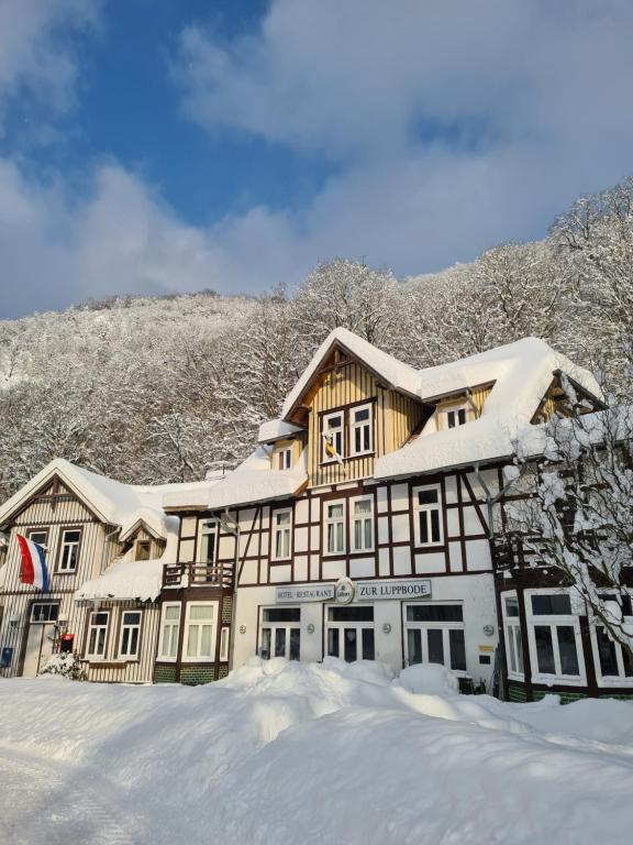 a large house covered in snow in front at Hotel Zur Luppbode in Treseburg