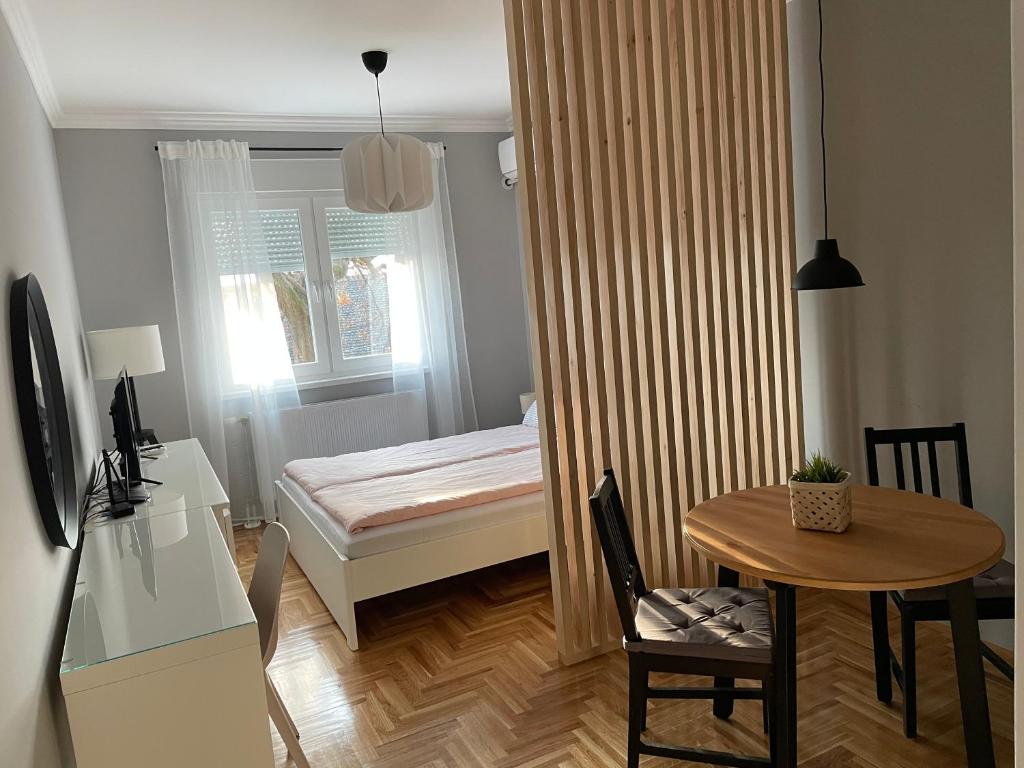 een kleine kamer met een kleine tafel en een bed bij Apartmani Sombor in Sombor