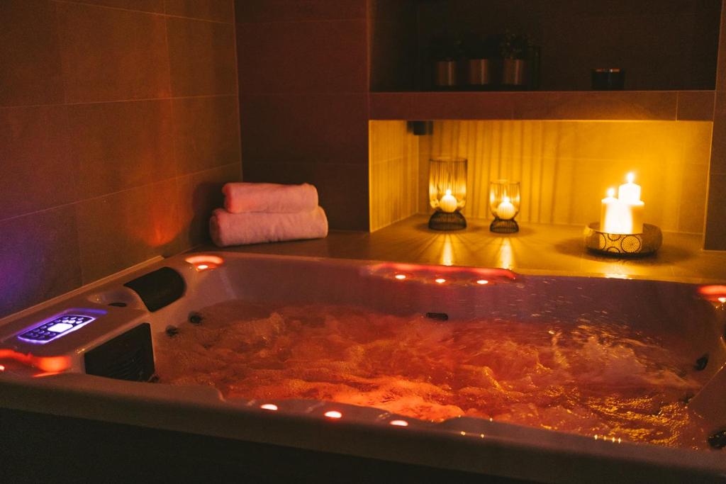 a large bath tub with a candle and two lights in it at SAVOY residence in Osijek