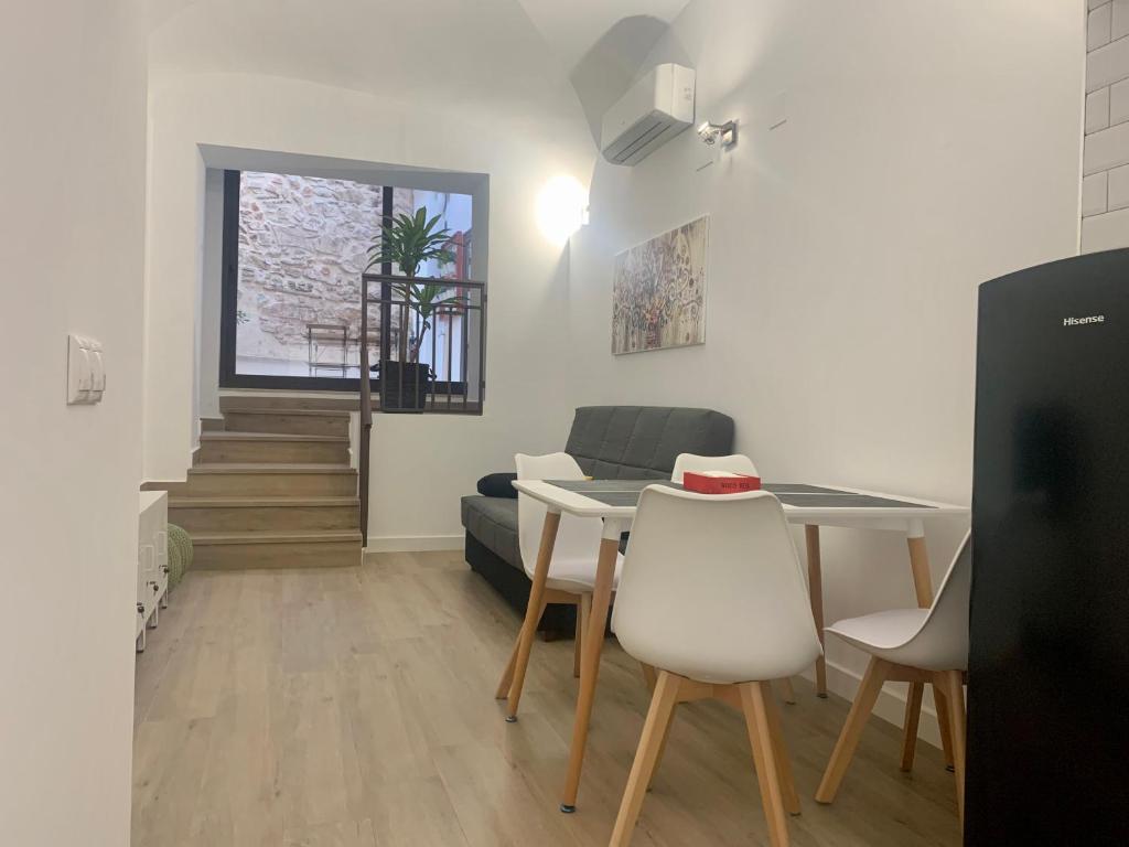 uma sala de estar com uma mesa e um sofá em PUERTA DE CACERES Apartamento 2 em Cáceres