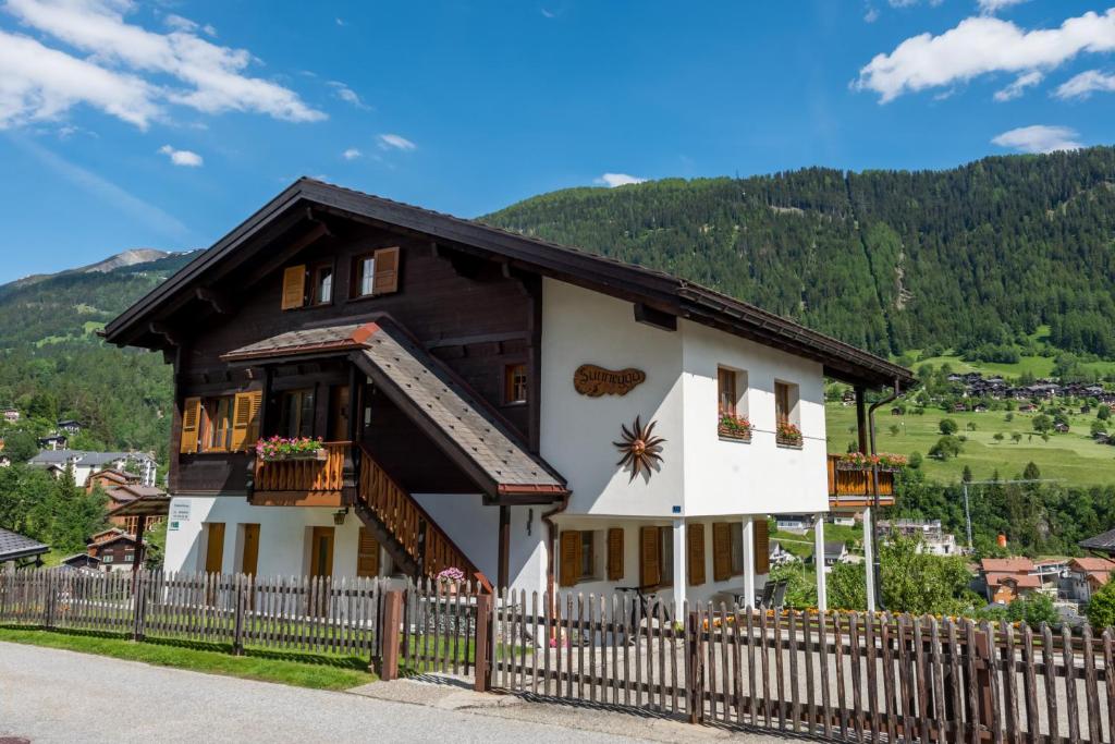 a house with a fence in front of it at Chalet Sunnegga in Fiesch