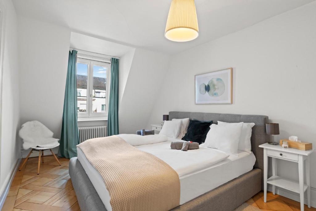 een slaapkamer met een groot wit bed en een raam bij Central Bright & Cozy Apartments in Luzern