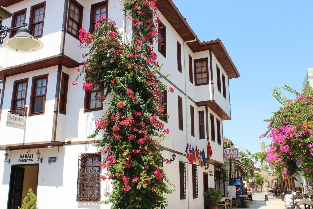 un edificio con dei fiori sul lato di Sabah Pansiyon a Antalya (Adalia)