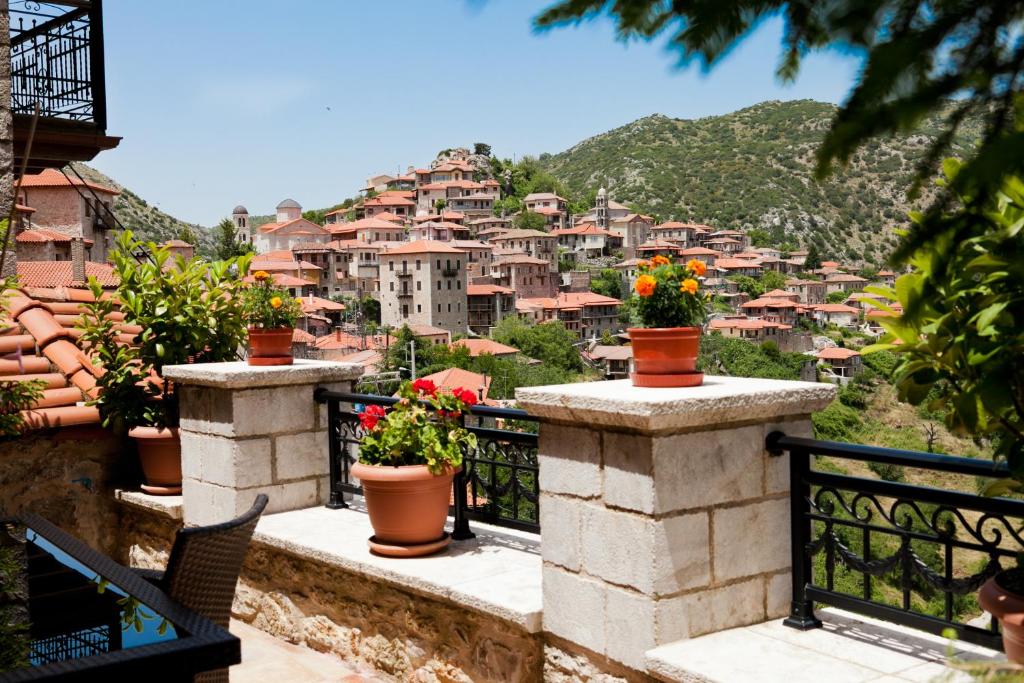 un balcón con vistas a la ciudad y macetas de flores en Amanites Guesthouse, en Dhimitsana