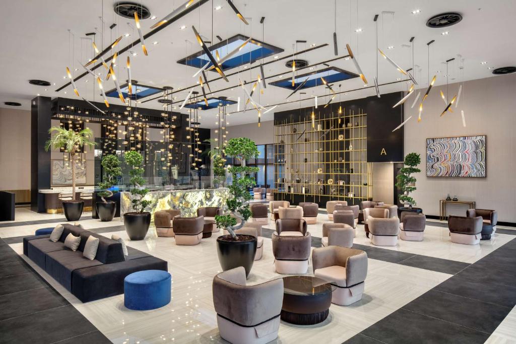 a lobby with couches and chairs in a building at Radisson Hotel Izmir Aliaga in Izmir