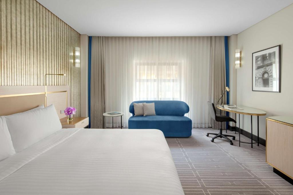 een hotelkamer met een bed en een blauwe stoel bij Radisson Blu Plaza Hotel Sydney in Sydney