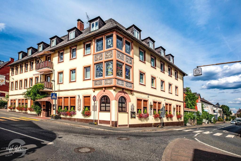 un grand bâtiment au coin d'une rue dans l'établissement Hotel Rüdesheimer Hof - Superior, à Rüdesheim am Rhein