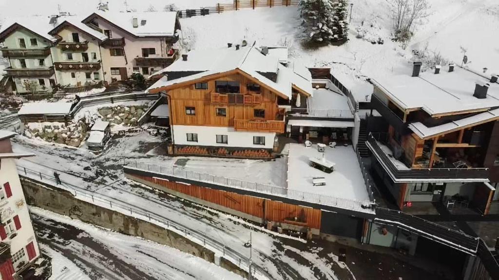 uma casa de madeira com neve no telhado em Cesa Prinoth em Campitello di Fassa