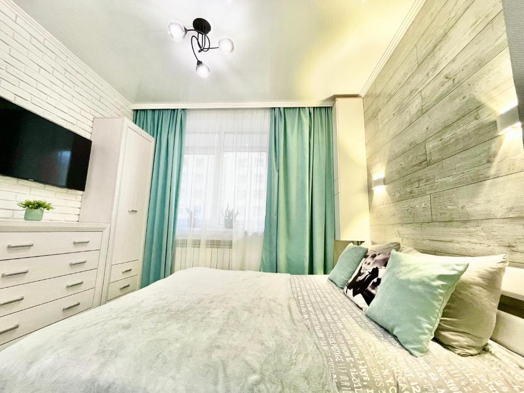 a bedroom with a large bed with a wooden wall at Tiffany Apartment in Irpin'