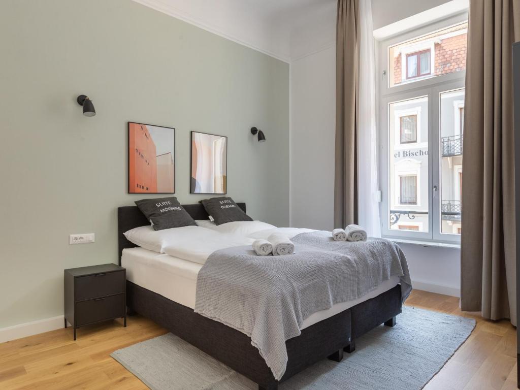 a bedroom with a bed and a large window at limehome Baden-Baden Bäderstraße in Baden-Baden