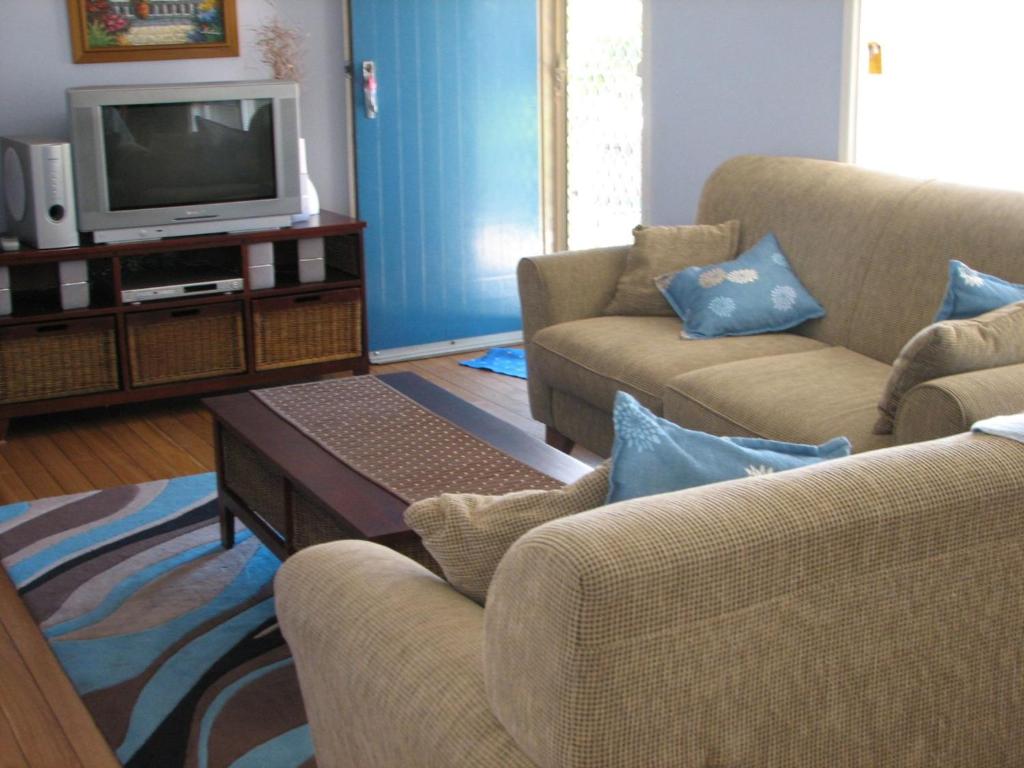 a living room with two couches and a tv at Horace Street 8 in Shoal Bay