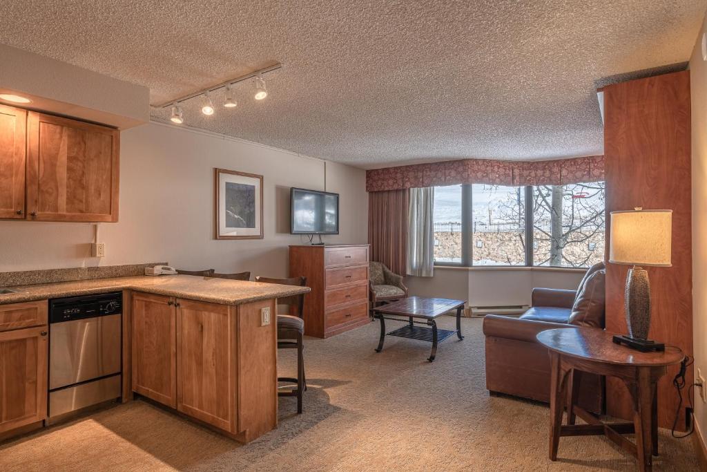 Il dispose d'une cuisine et d'un salon avec un canapé et une table. dans l'établissement Grand Lodge 1-Bedroom Condo with 3 Queens & Close to Everything condo, à Crested Butte