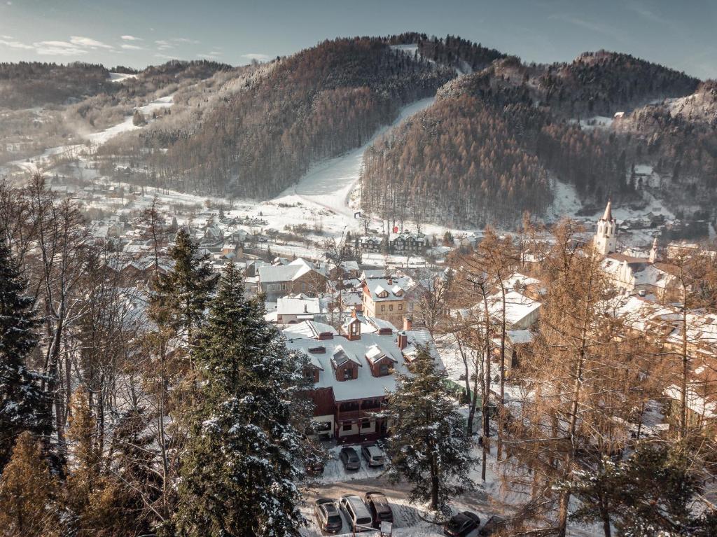 eine schneebedeckte Stadt mit Bäumen und Bergen in der Unterkunft Hotel Batory in Szczawnica