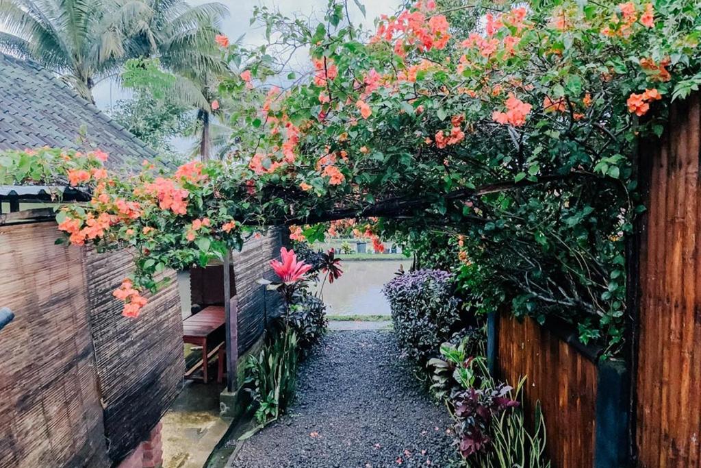 a garden tunnel with flowers on a fence at Lesehan Cahaya Tetebatu Inn Syariah at Desa Wisata in Tetebatu