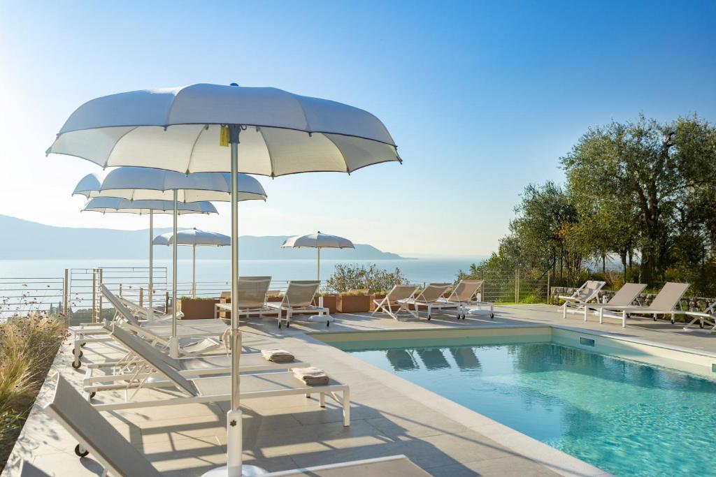 - une piscine bordée de chaises longues et de parasols dans l'établissement Relais Zenner, à Toscolano Maderno