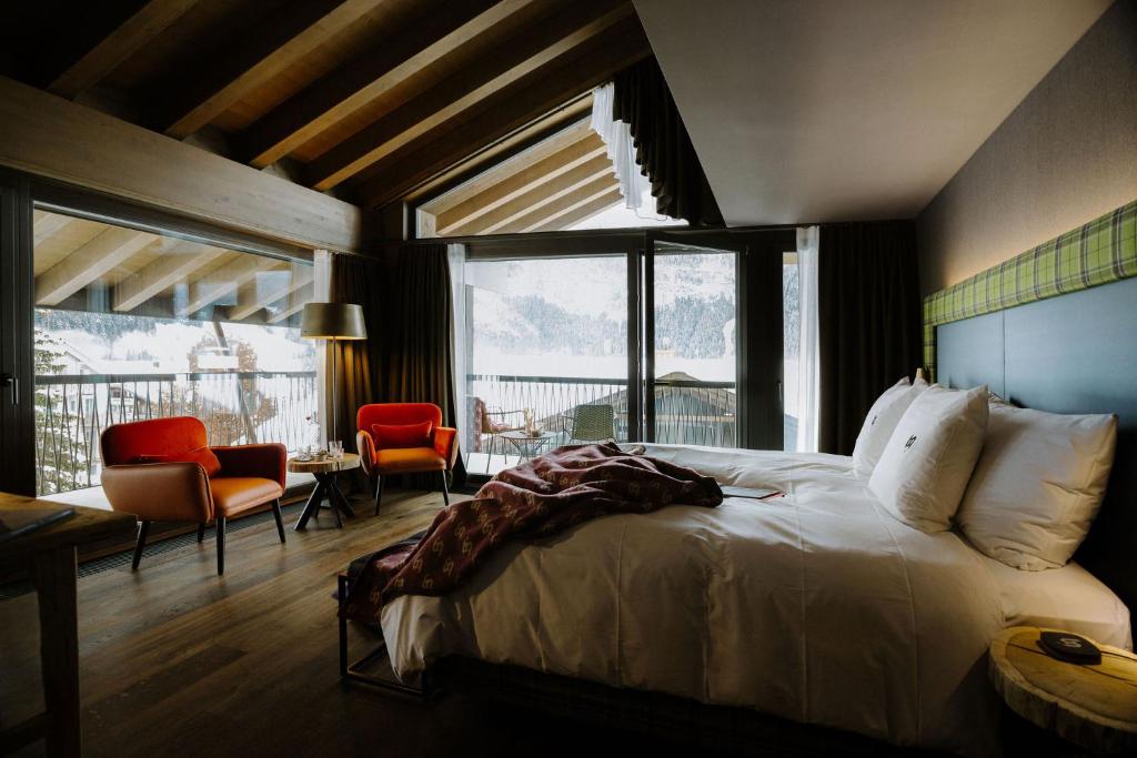 um quarto com uma cama, uma mesa e cadeiras em Bergwelt Grindelwald - Alpine Design Resort em Grindelwald