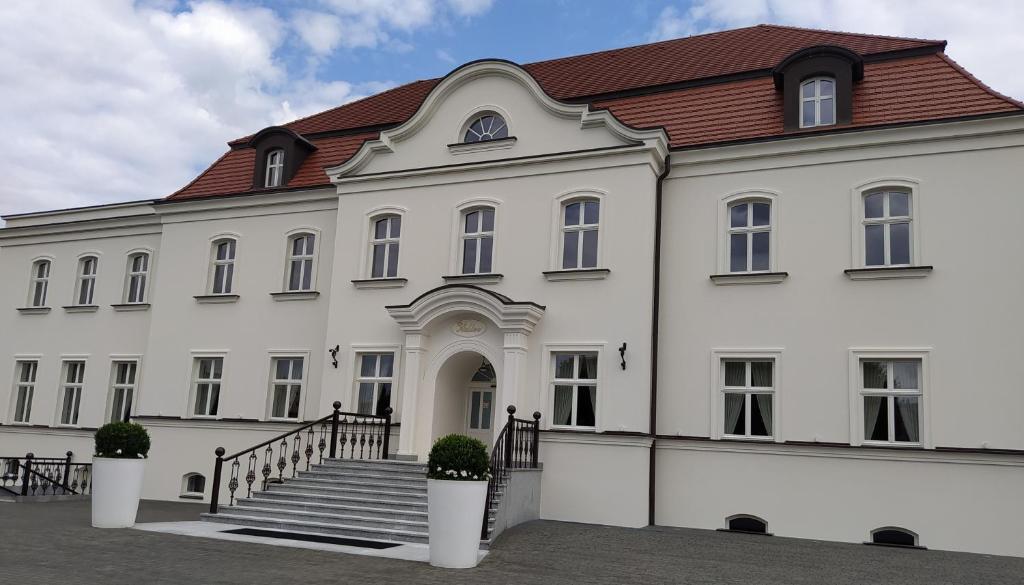 a large white building with a red roof at Adler in Swarzędz