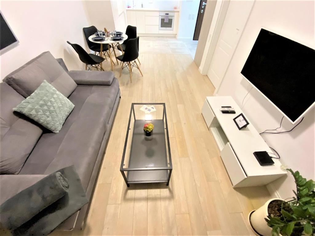 a living room with a couch and a table at EXCLUSIVE 2BR! Apartment in CENTER +NETFLIX +GYM in Warsaw