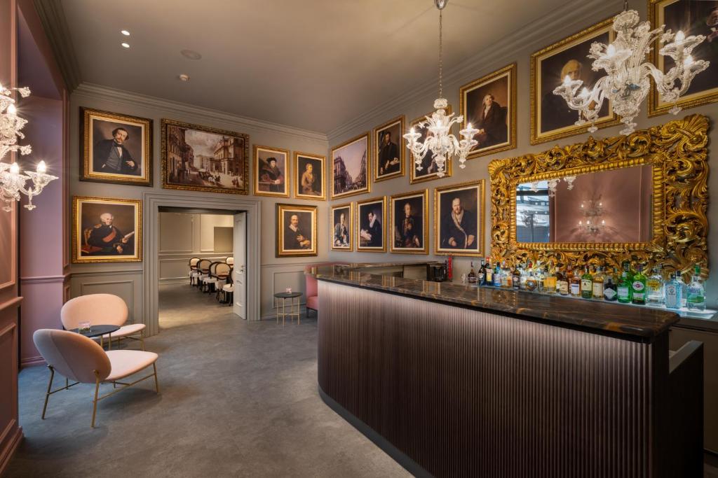 een bar in een kamer met portretten aan de muur bij WorldHotel Casati 18 in Milaan