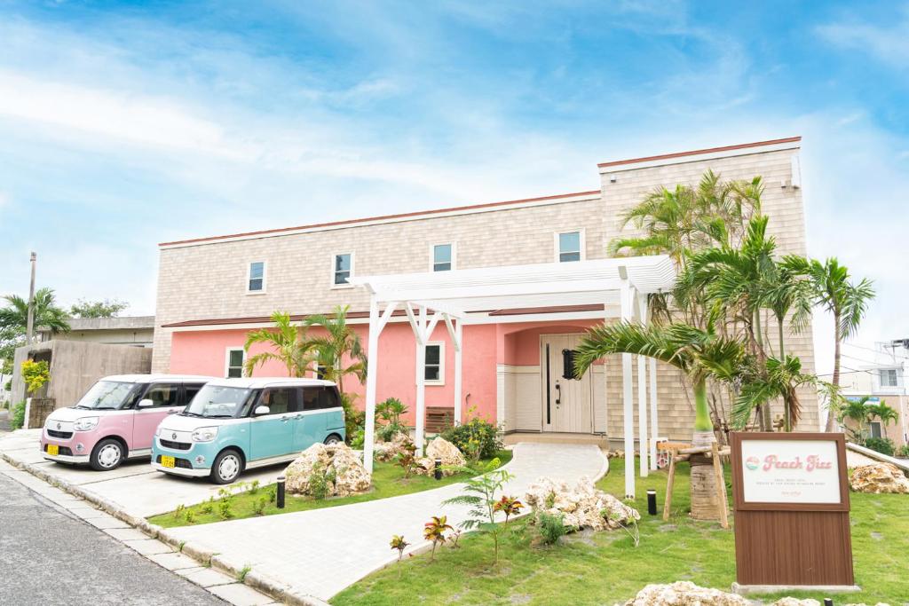 ein rosa Haus mit einem Van davor geparkt in der Unterkunft Palm Springs Miyakojima Resort in Miyako-jima