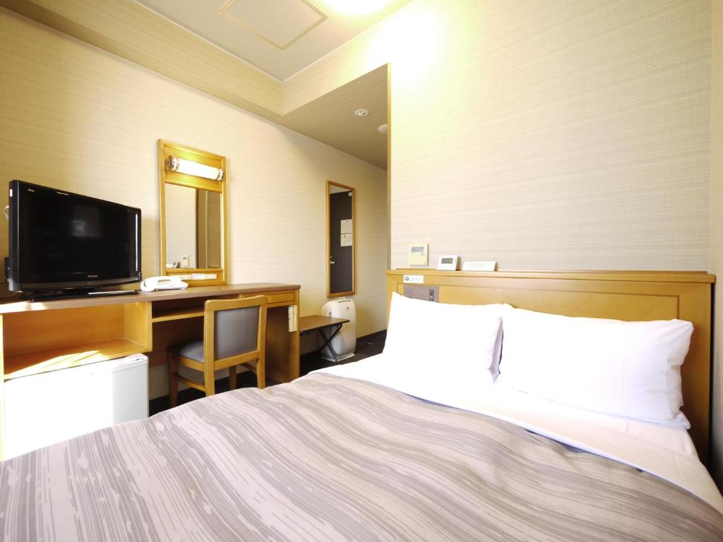 Hotel Route-Inn Nagoya Higashi Betsuin في ناغويا: غرفة في الفندق مع سرير ومكتب