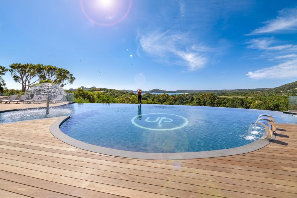 een zwembad met een houten terras en een blauwe lucht bij U Paesolu in Sainte-Lucie de Porto-Vecchio