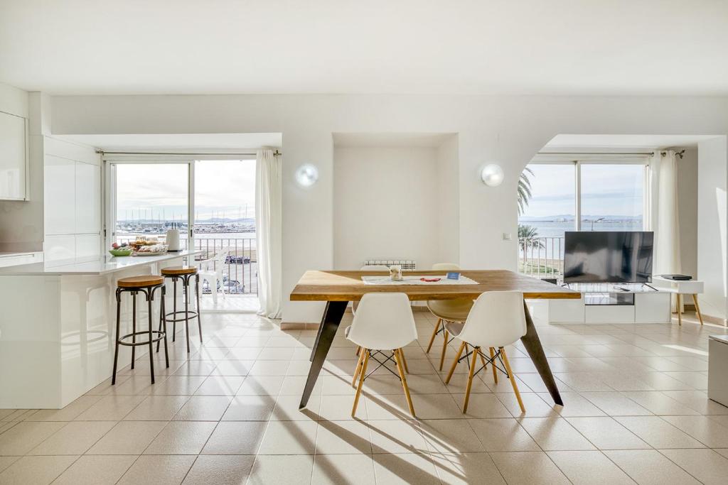 a kitchen with a table and chairs and a television at Apartamento Roses Playa in Roses