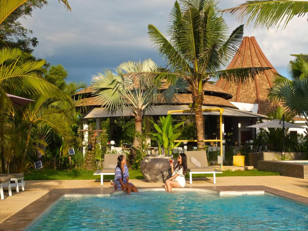 un grupo de personas sentadas en la piscina de un complejo en Barong Resort, en Ban Phe